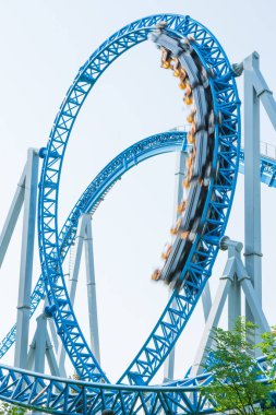 Mavi gökyüzüne karşı lunapark treni. Lunaparktaki lunaparkta hız treni. Eğlence parkında neşeli eğlenceler.