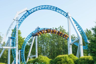 Mavi gökyüzüne karşı lunapark treni. Lunaparktaki lunaparkta hız treni. Eğlence parkında neşeli eğlenceler.