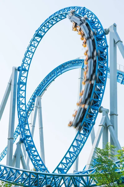 Mavi gökyüzüne karşı lunapark treni. Lunaparktaki lunaparkta hız treni. Eğlence parkında neşeli eğlenceler.