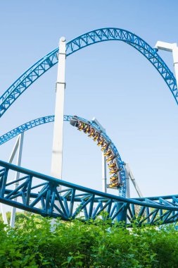 Mavi gökyüzüne karşı lunapark treni. Lunaparktaki lunaparkta hız treni. Eğlence parkında neşeli eğlenceler.