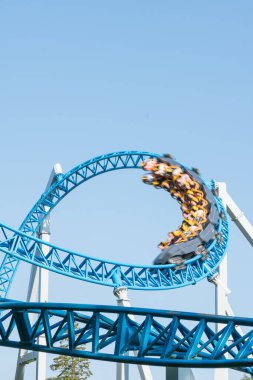 Mavi gökyüzüne karşı lunapark treni. Lunaparktaki lunaparkta hız treni. Eğlence parkında neşeli eğlenceler.