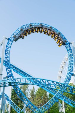 Mavi gökyüzüne karşı lunapark treni. Lunaparktaki lunaparkta hız treni. Eğlence parkında neşeli eğlenceler.