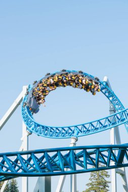 Mavi gökyüzüne karşı lunapark treni. Lunaparktaki lunaparkta hız treni. Eğlence parkında neşeli eğlenceler.