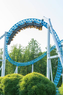 Mavi gökyüzüne karşı lunapark treni. Lunaparktaki lunaparkta hız treni. Eğlence parkında neşeli eğlenceler.