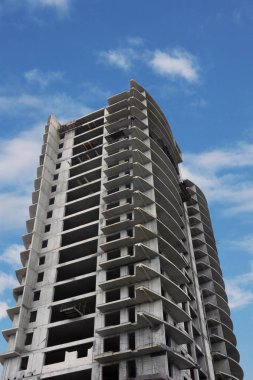 Mavi gökyüzüne karşı yapım aşamasında olan yüksek bina