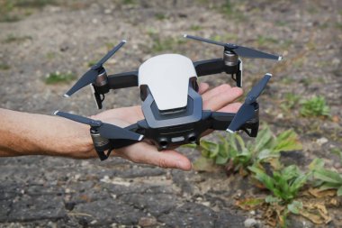 Kişinin elinde dört rotor ile insansız uçak kalkışa hazırdır