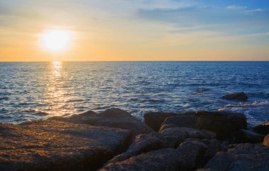 Kayalık deniz kıyısı ve günbatımı denize
