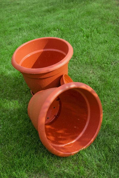 Two plastic ornamental flowerpot brown stands  on a grass — Stock Photo, Image