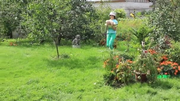 소녀는 정원에서 잔디밭에 그녀의 호박을 — 비디오