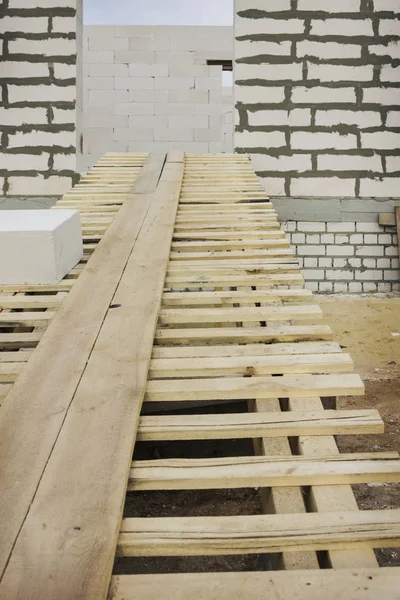 Enter a wooden gangway intol building under construction — Stock Photo, Image