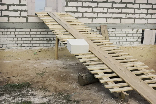 Houten ladder bij de ingang van het huis in aanbouw — Stockfoto