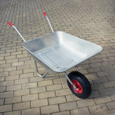 Taş zeminde el arabası. Tek tekerlekli metal araba. 