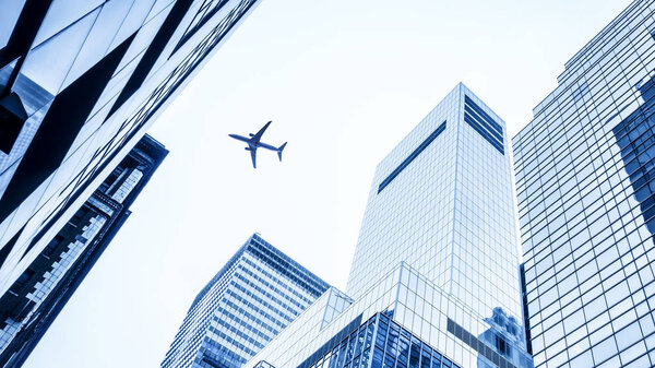 Low angle plane flying over modern buildings of New York City