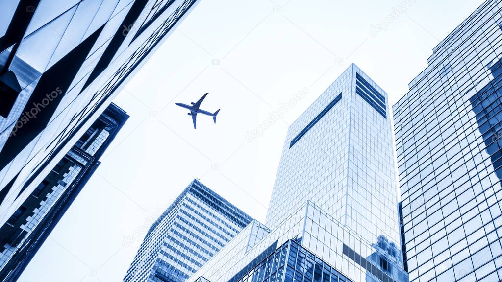 low angle plane flying over modern buildings of New York City