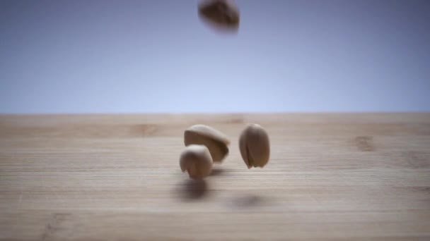Slow Motion Pistachios Wooden Background — Stock Video