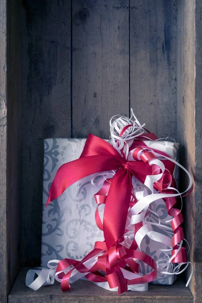 Presente Natal Com Uma Fita Vermelha Fundo Caixa Madeira — Fotografia de Stock