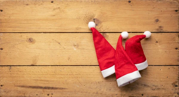 Uma Imagem Três Chapéus Vermelhos Papai Noel Com Fundo Madeira — Fotografia de Stock