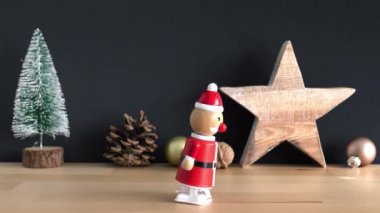 Bir oyuncak Noel Baba throug Noel dekorasyonu yürür ve tablodan düşüyor