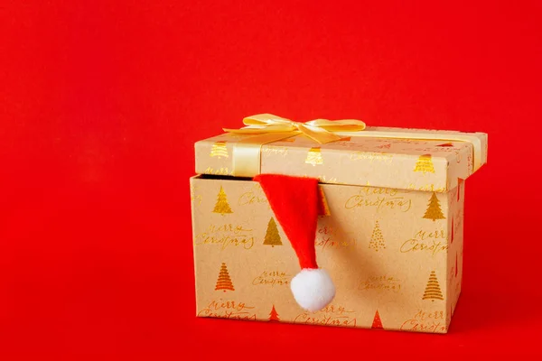 Uma Caixa Presente Natal Com Chapéu Papai Noel Fundo Vermelho — Fotografia de Stock
