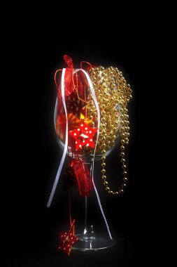 Kırmızı yıldızlar ve altın perls siyah zemin üzerine bir Noel dekorasyon şarap cam