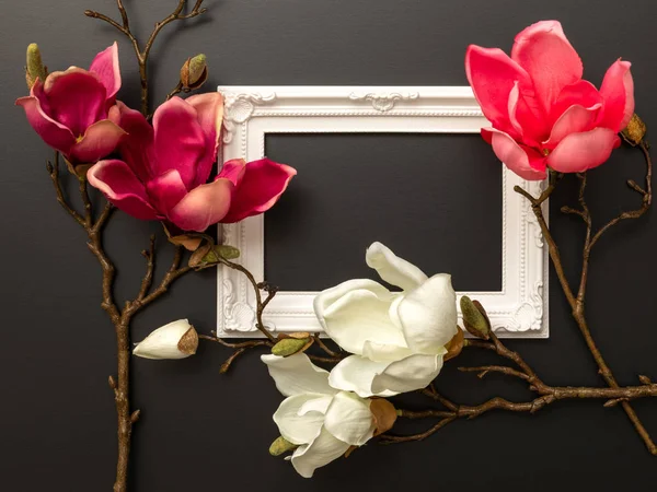 An image of some magnolia flowers on a black background with space for your message
