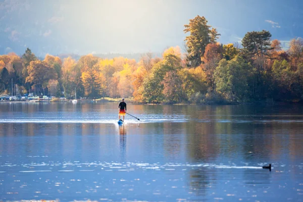 Stand up paddling man på hösten sjön — Stockfoto