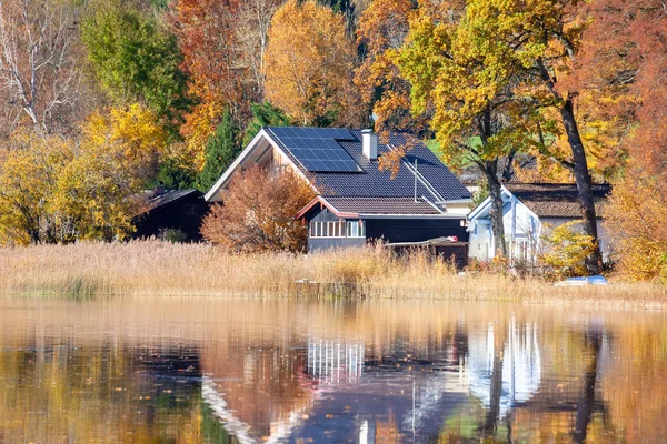 Hus vid sjön med solpaneler på taket — Stockfoto