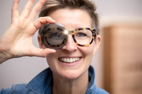 Woman with glasses looking through tinted glass — Stock Photo, Image