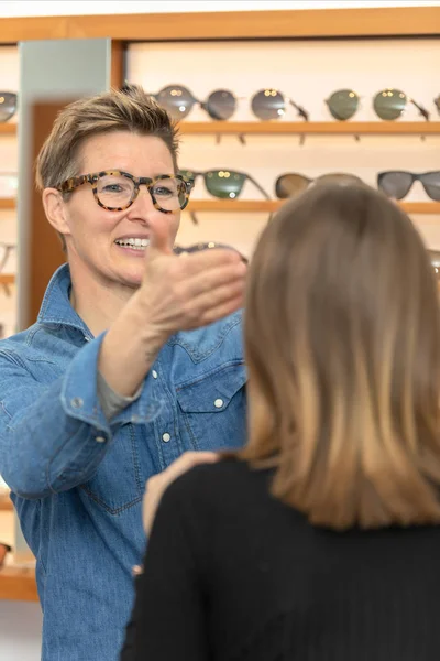 Vrouw in een winkel van brillen — Stockfoto