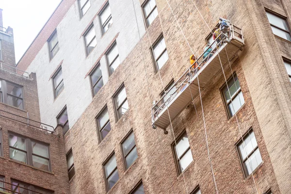 Travailleurs suspendus sur une façade de maison à New York — Photo