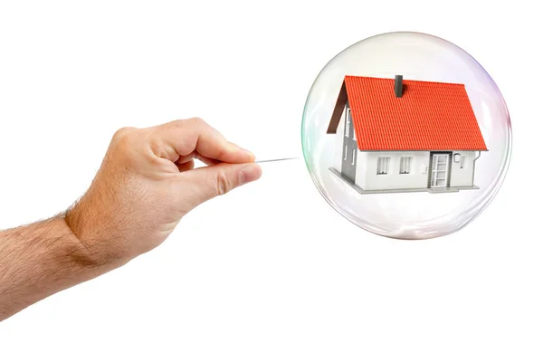 Soap bubble with a house and a males hand with needle to let the — Stock Photo, Image