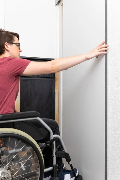Mujer discapacitada abre una puerta en su piso —  Fotos de Stock