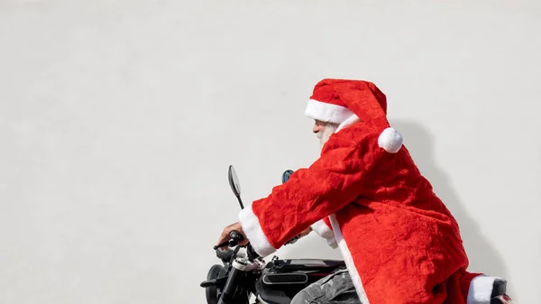 Homem em uma moto em um traje típico de Papai Noel — Fotografia de Stock