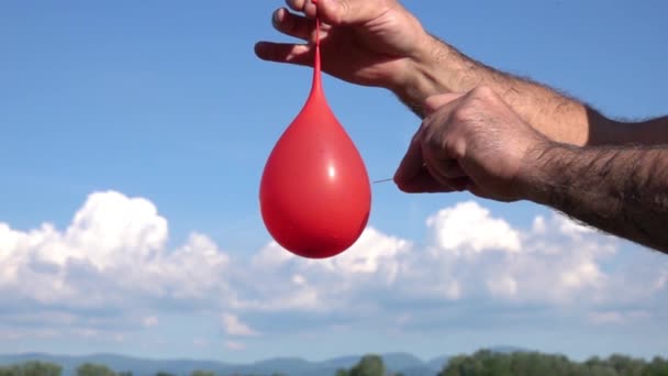 Slow Motion Van Mannelijke Hand Pierce Rode Luchtballon Met Water — Stockvideo