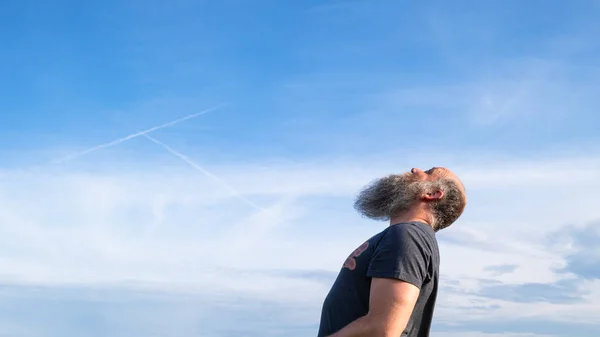 Mand ser op til den blå himmel - Stock-foto