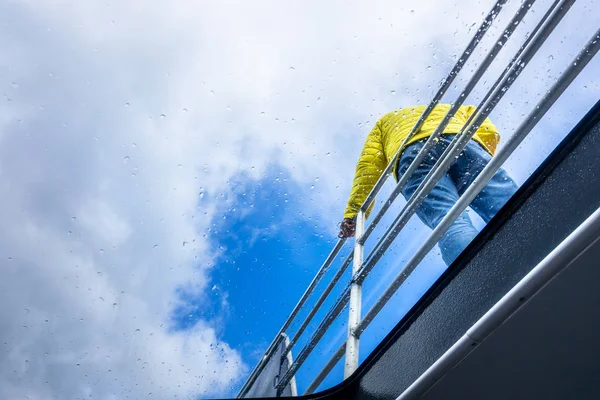 Regenachtige dagtour man bij een reling — Stockfoto