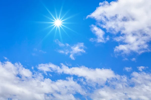 Blauer Himmel mit riesigen weißen Wolken und Sonnenhintergrund — Stockfoto