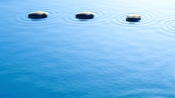 Piedras de guijarro en el agua con fondo ondulado —  Fotos de Stock