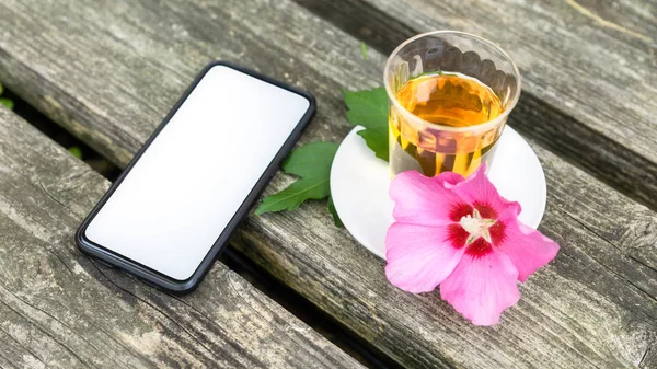 Молочный чай со смартфоном на старом деревянном фоне — стоковое фото