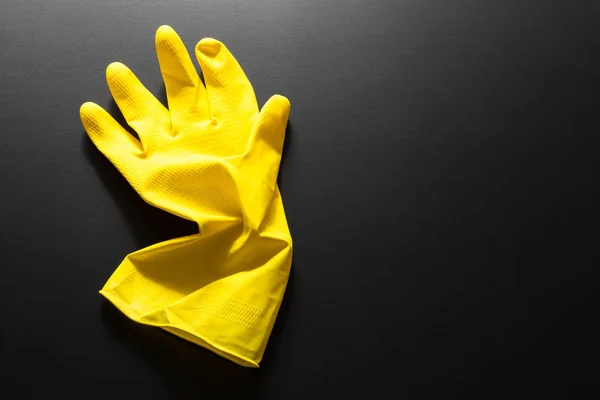 黄色橡胶手套隔离在黑色背景上 — 图库照片