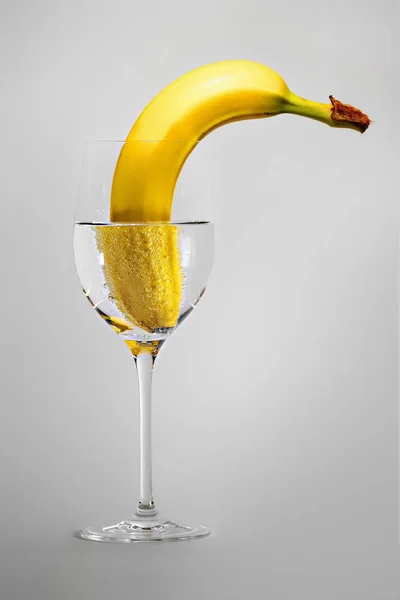 Banane im Weinglas mit Wasser — Stockfoto