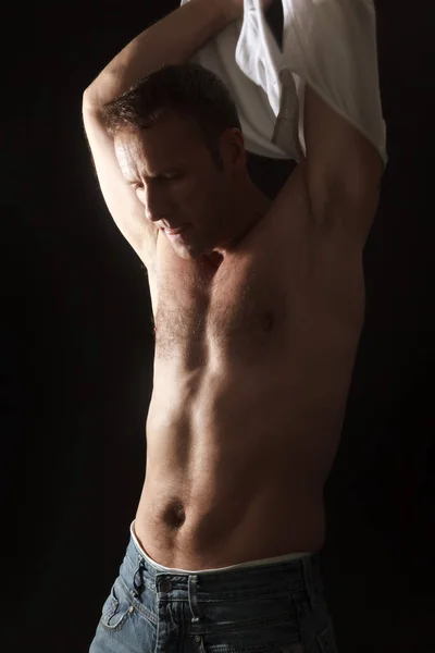 Красивый мускулистый мужчина, поднимающий рубашку — стоковое фото