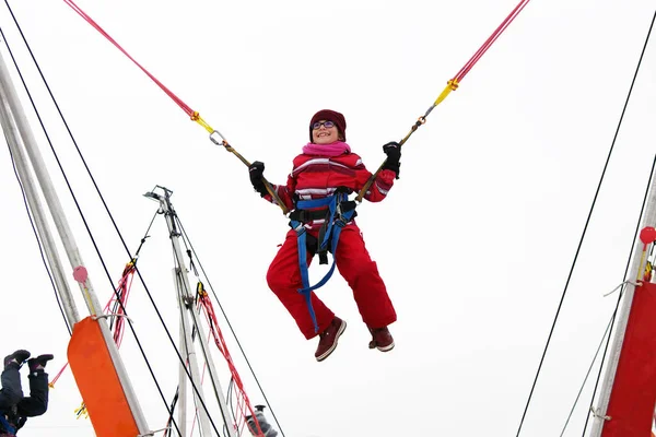 Küçük Kız Bungee Jumping Kış Festivali Sırasında Trambolin Üzerinde — Stok fotoğraf
