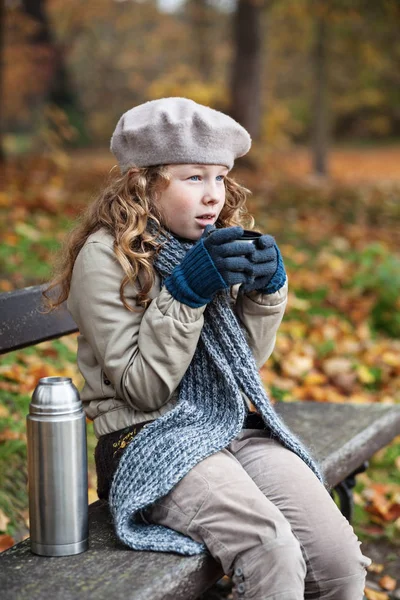 Menina em panos de inverno beber de copo de frasco — Fotografia de Stock
