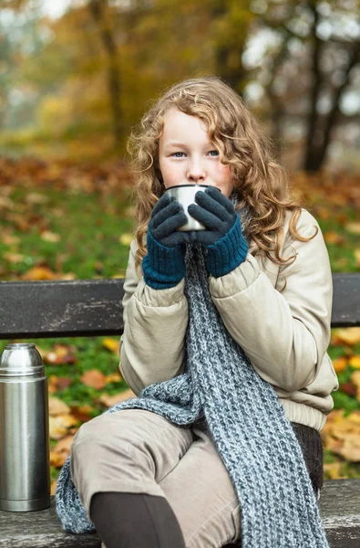 Chica en paños de invierno beber de la taza del frasco —  Fotos de Stock