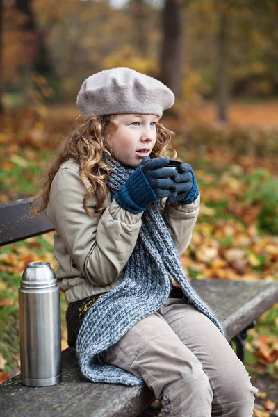 Menina em panos de inverno beber de copo de frasco Imagens De Bancos De Imagens Sem Royalties