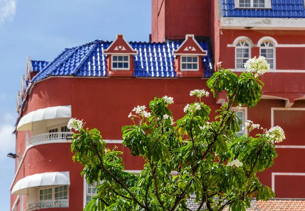 Kvetoucí strom s červenou budovu v pozadí — Stock fotografie