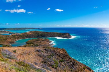 Mavi Suda Beyaz Sörf Antigua sahilindeki körfezleri ve körfezleri vuruyor