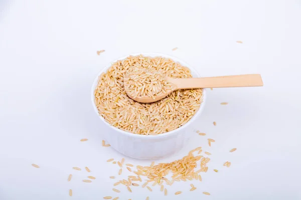 Riz brun dans un bol blanc avec cuillère en bois — Photo