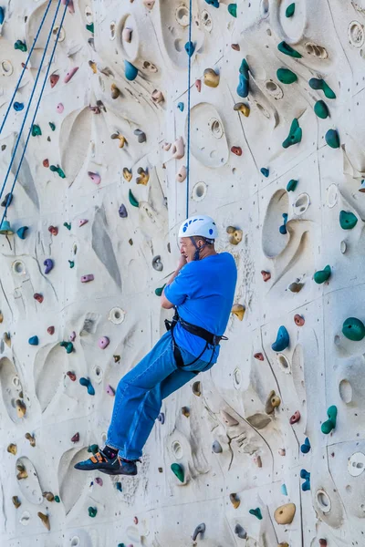 Homem de meia-idade na parede de escalada — Fotografia de Stock